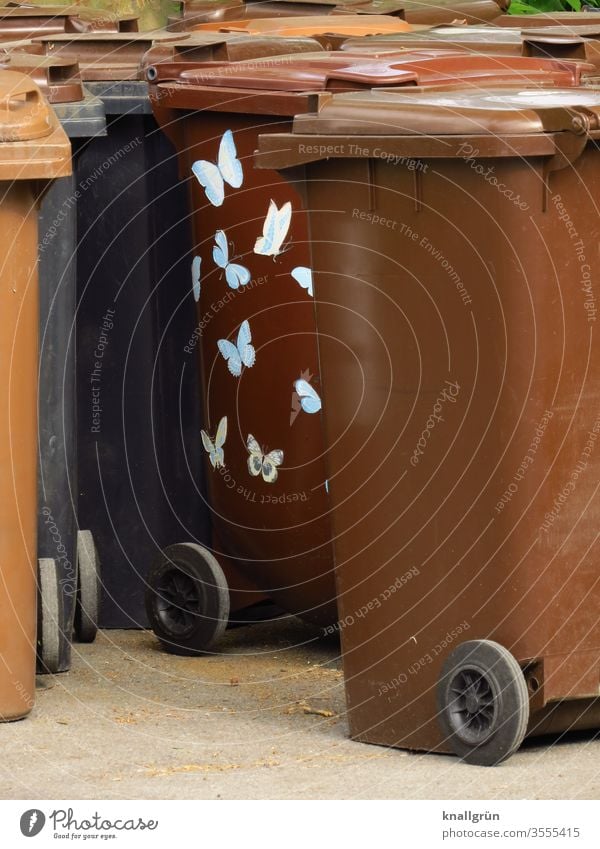 Braune Mülltonnen, eine davon mit hellen Schmetterlingsaufklebern Schilder & Markierungen Aufkleber braun Farbfoto Menschenleer weiß Tag Textfreiraum rechts