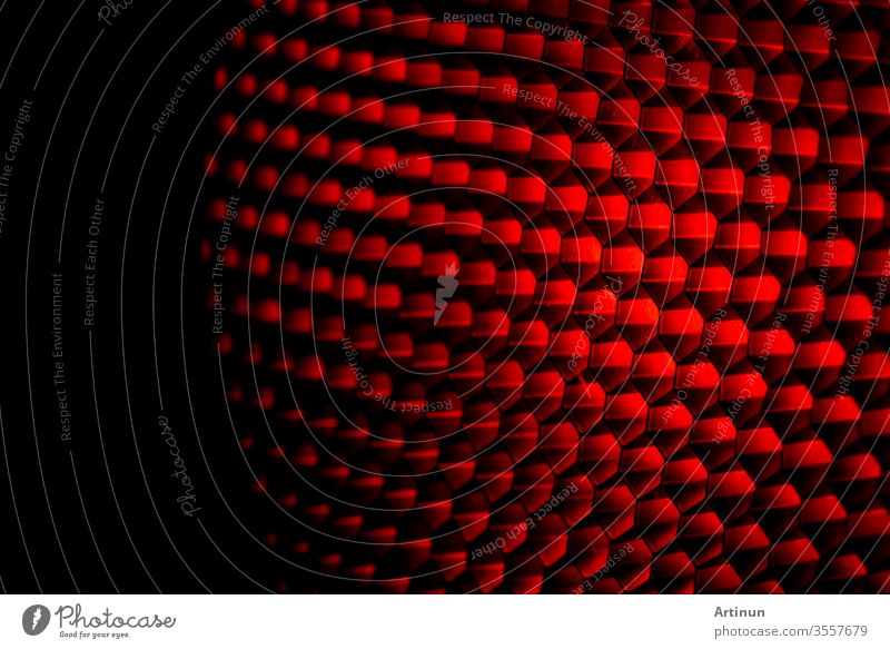 Nahaufnahme Wabengittertextur mit rotem Licht. Rotes und dunkles Metall mit sechseckigem Muster und abstraktem Hintergrund. Ausrüstung mit Lichtmodifikatoren. Metall-Wabenstruktur. Futuristisches Muster. Honiggitterzellen-Netzwerk.
