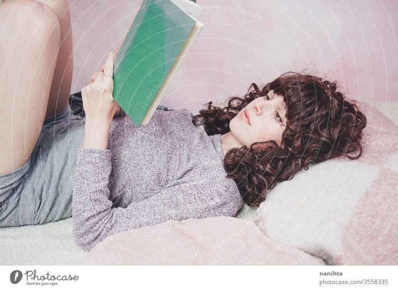 Junge brünette Frau liest in ihrem Schlafzimmer ein Buch lesen Schüler Raum müde sich[Akk] entspannen lernen heimwärts zu Hause genießen Kultur Freizeit hübsch
