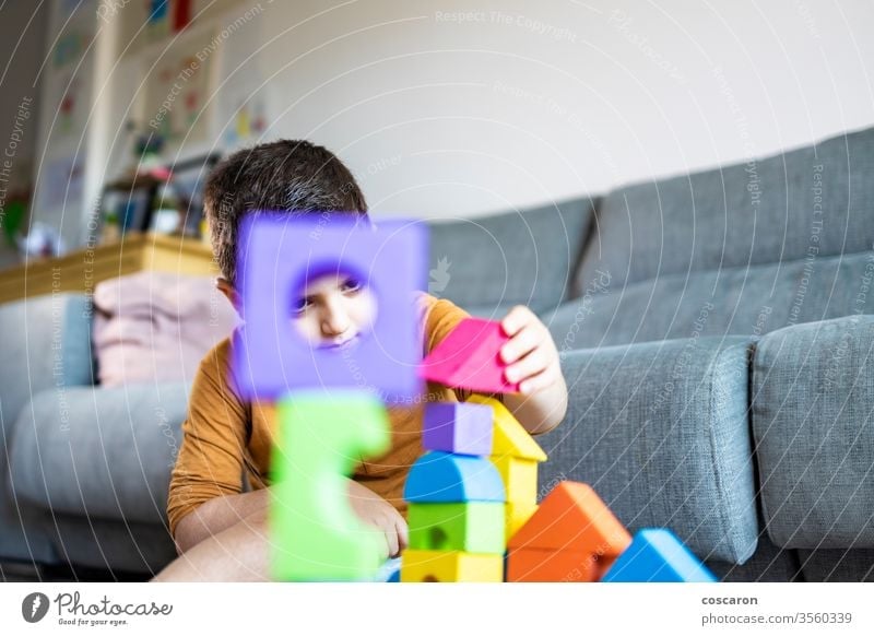 Lustiger Junge spielt zu Hause mit Blöcken Aktivität bezaubernd Baby schön Schlafzimmer Klotz Baustein bauen Kaukasier Kind Kindheit Farbe farbenfroh