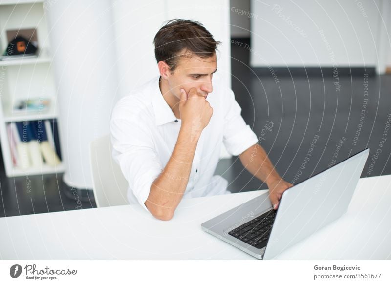 Junger Mann im Büro Business Schreibtisch Laptop Blick gutaussehend Unternehmen Problem weiß Sitzen Erwachsener copyspace entschlossen Beruf Licht involviert