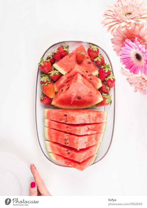 Wassermelonenscheiben auf Tablett auf weißem Holztisch Sommer erdbeeren Scheiben Keramik Hände rosa hölzern Frau Tisch frisch Snack Beeren Blumen lecker schön