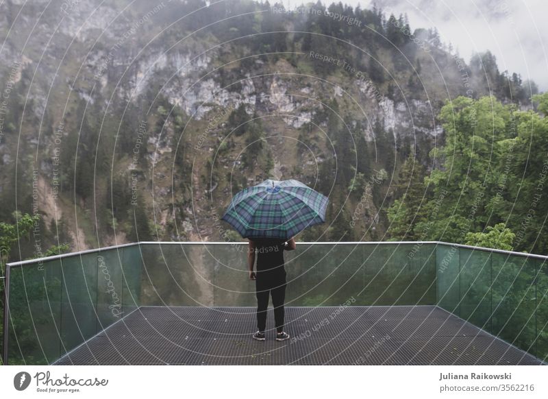 Mann mit Regenschirm vor Bergpanorama Berge u. Gebirge Mensch Einsamkeit ruhig Alpen Landschaft Panorama (Aussicht) Traurigkeit düster Nebel wandern