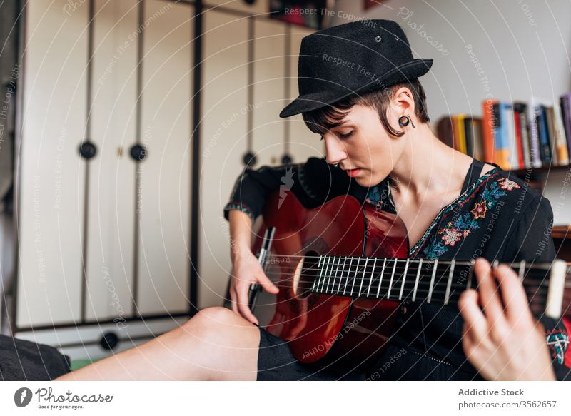 Ruhige Frau spielt Gitarre im Schlafzimmer spielen Musik akustisch Instrument Windstille ruhig trendy Melodie Klang Bett sitzen Hobby Musiker Gesang
