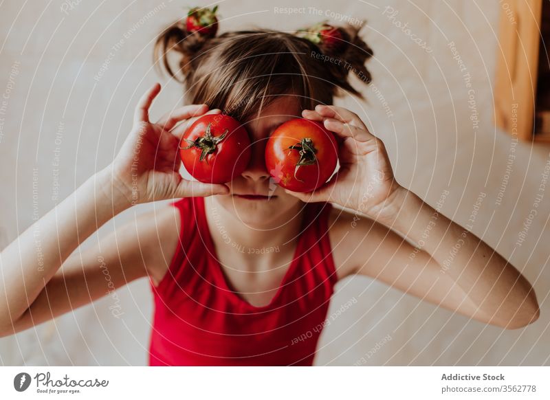 Kleines Mädchen amüsiert sich mit Tomaten Spaß Küche heimwärts Auge Konzept rot hell Farbe frisch niedlich Kind spielen gemütlich Gemüse Freude Lebensmittel
