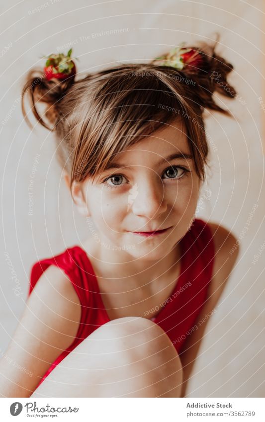 Süßes Mädchen mit Erdbeeren im Haar Haarknoten Lächeln Konzept niedlich Gesundheit frisch heiter süß Kind Glück Lebensmittel natürlich Kindheit Freude Frau