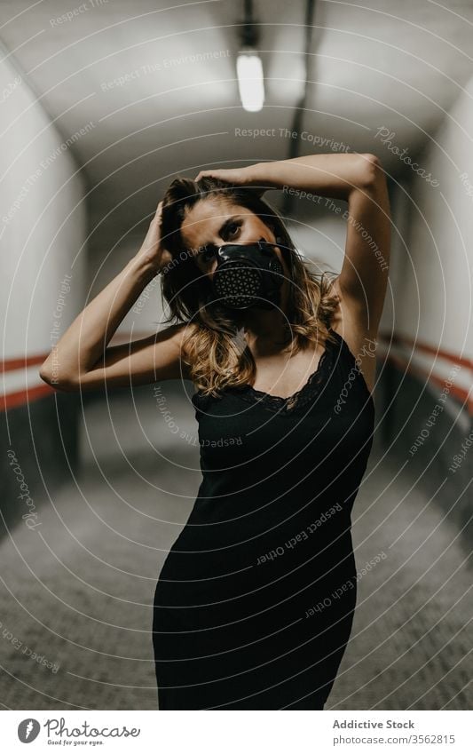 Positive Frau mit Schutzmaske steht im Korridor Mundschutz COVID Coronavirus verhindern behüten positiv Gang Pandemie Konzept Gebäude sicher Krankheit Gefahr