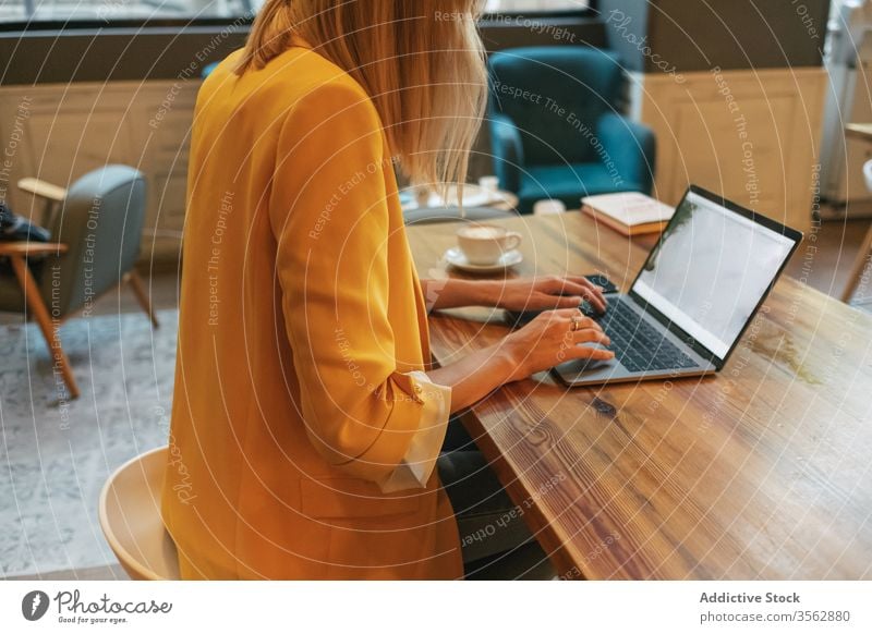 Erwachsene Frau trinkt aromatischen Kaffee, während sie im Café am Laptop arbeitet freiberuflich benutzend schäumen Internet Latte trinken Tasse heimwärts