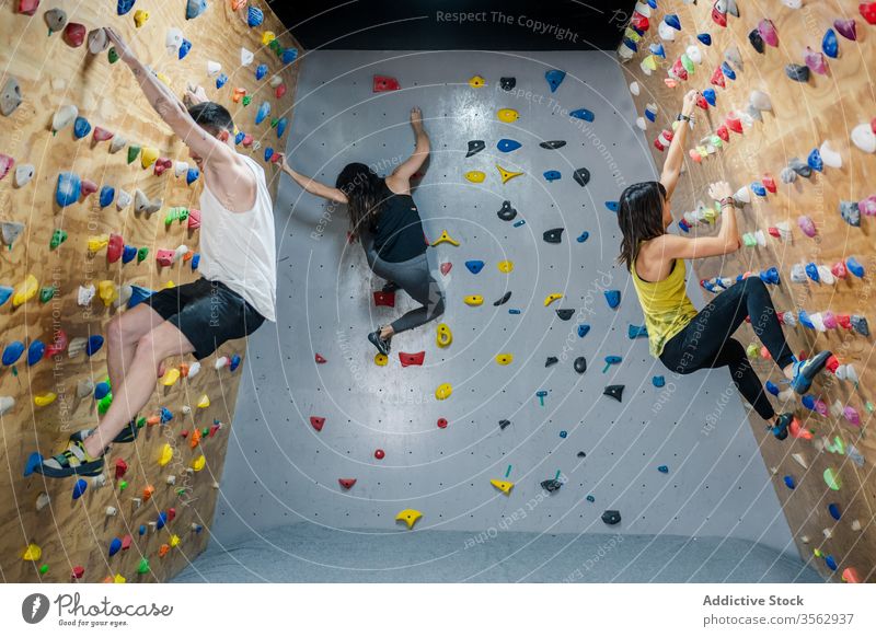 Bergsteiger in Sportkleidung an der Wand in der Turnhalle Herausforderung Energie Mann stark Kraft Felsbrocken Lifestyle Menschengruppe sich[Akk] bewegen