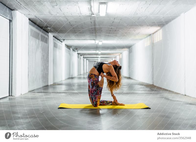 Flexible Frau macht Yoga in Kamel-Haltung üben Asana Camel Garage Wegbiegung ardha bhekasana ustrasana Pose Rücken positionieren Gleichgewicht jung Wellness