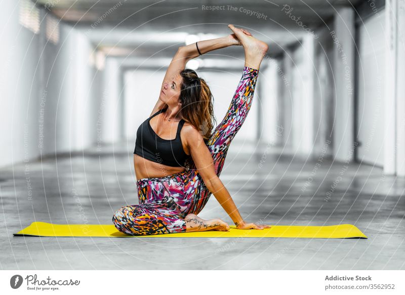 Frau dehnt Körper in Yogastellung üben Dehnung Kompass Asana Pose Garage positionieren parivrita surya yantrasana beweglich fortgeschritten Herausforderung