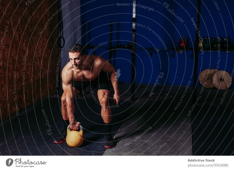 Muskulöser Sportler, der mit der Kettlebell im Fitnessstudio trainiert Übung pendeln operativ Athlet harte Arbeit heben Bestimmen Sie männlich stark schwer