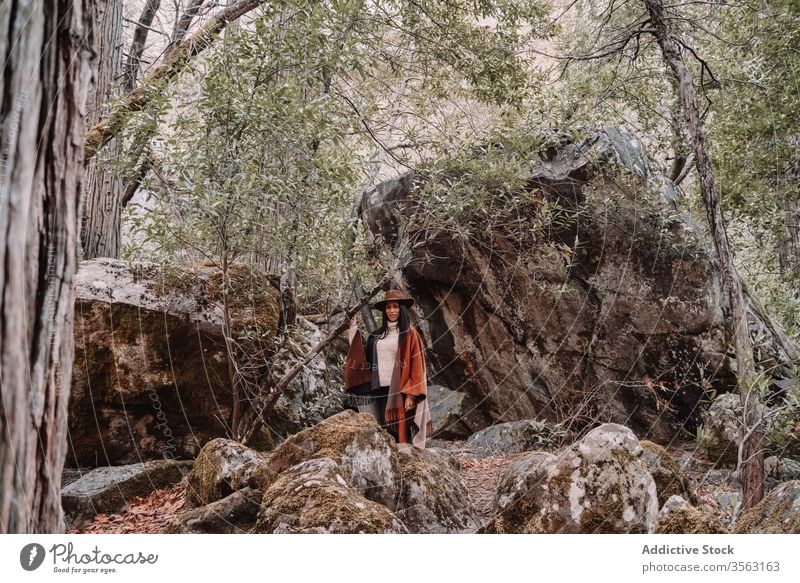 Junge Frau steht neben großen Steinen im Wald Felsen Felsbrocken reisen trendy Stil Baum Landschaft yosemite Park Boho rustikal Vereinigte Staaten