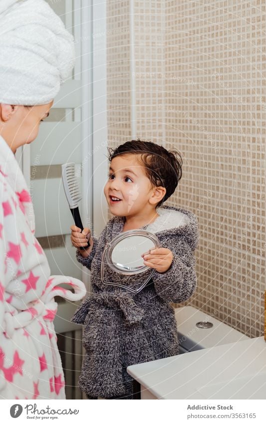 Kleiner Junge bürstet Haare im Badezimmer Bürste Behaarung Kamm Mutter Kind bezaubernd nasses Haar Spiegel Kindheit Elternschaft Mama Sohn Mutterschaft hell