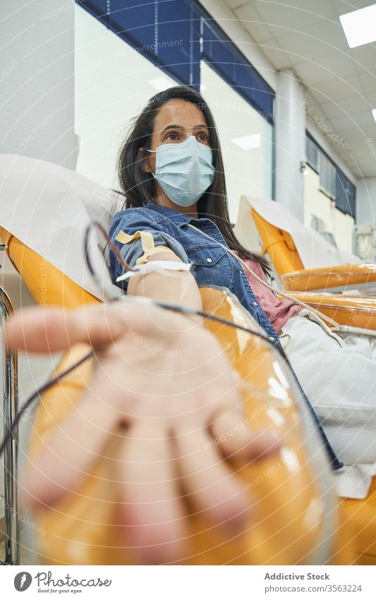 Weibliche Spenderin beim Blutspenden im Krankenhaus schenken Frau medizinisch Transfusion Hämatologie sich[Akk] entspannen Mundschutz Selbstlosigkeit Verfahren