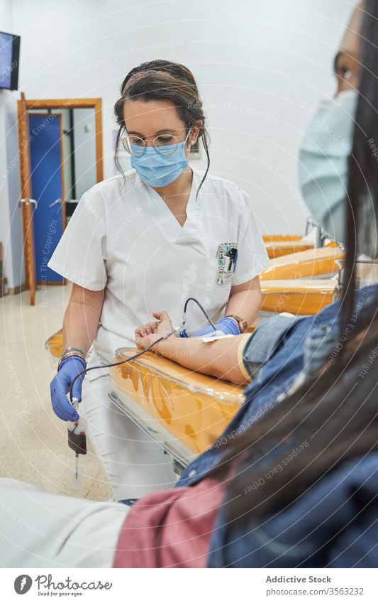Krankenschwester injiziert dem Patienten während der Bluttransfusion einen Katheter schenken Spender Krankenpfleger Einspritzung medizinisch Frau Transfusion
