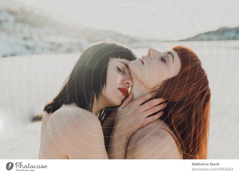 Zärtliches lesbisches Paar im sonnigen Winterfeld Frauen Liebe sinnlich berühren Verlockung lgbt Angebot Zusammensein Natur gleichgeschlechtlich Umarmen
