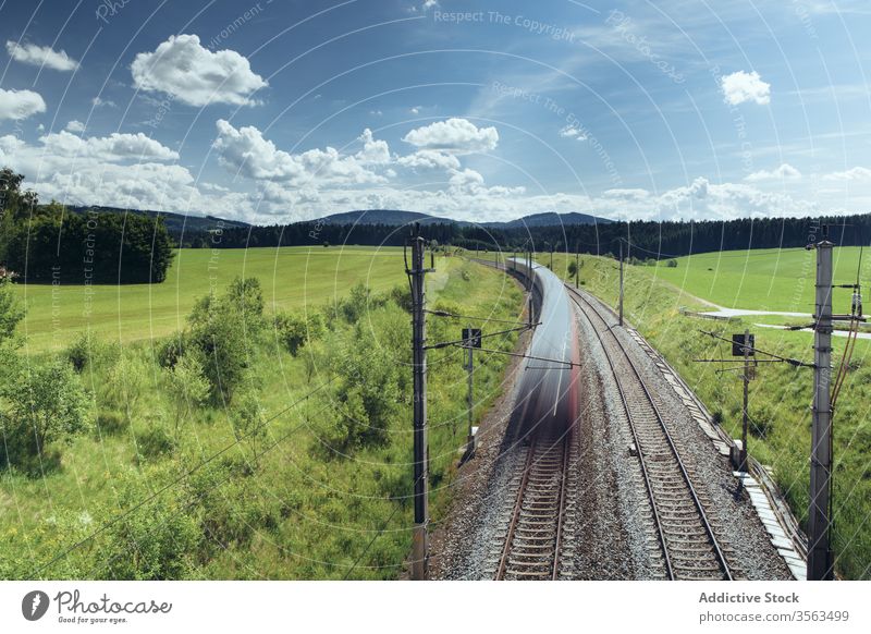 Malerische Szenerie eines Schnellzuges auf der Eisenbahn Zug Landschaft Mitfahrgelegenheit schnell Feld Berge u. Gebirge Langzeitbelichtung majestätisch