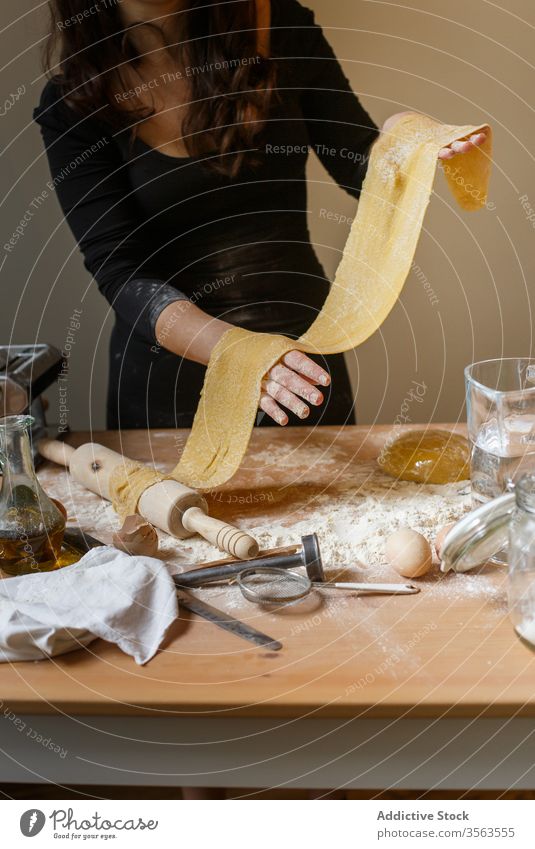 Gesichtslose Frau mit gerolltem Teig in der Küche Teigwaren elastisch Spätzle selbstgemacht Koch Mehl roh Küchengeräte rollen Speise Ei vorbereiten Bestandteil