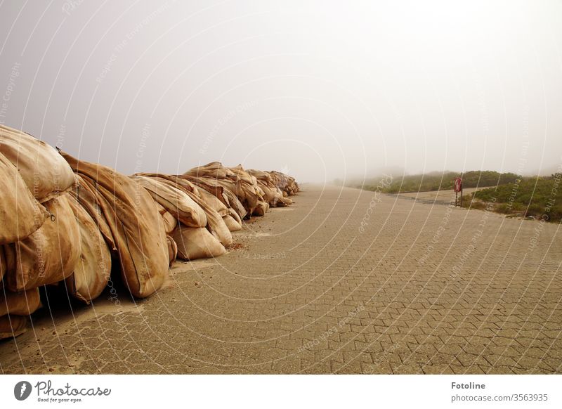 Schutzwall - oder riesige Sandsäcke, die  die Insel vor den Fluten schützen verschwinden im Nebel Sandsack Menschenleer menschenleer Farbfoto Außenaufnahme