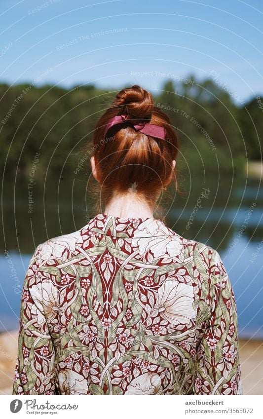 Rückansicht einer jungen Frau allein in der Natur Mädchen anonym Depression Einsamkeit soziale Distanzierung Rückseite Rücken See Stehen geblümt Kleid