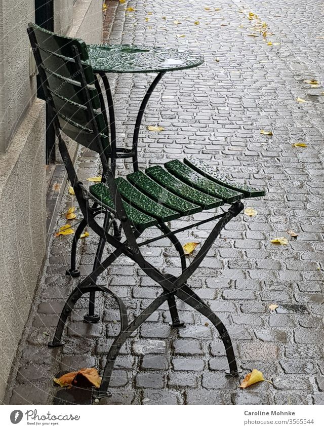 Grüner Bistrostuhl und Tisch im Regen stehen gelassen tisch bistrostuhl bistrotisch Häusliches Leben Farbfoto Tag Menschenleer Außenaufnahme Möbel