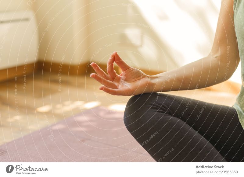Nutzpflanzenfrau in Lotus-Pose auf Matte Yoga Mudra Frau gestikulieren Übung padmasana Sportbekleidung Unterlage Windstille üben Achtsamkeit stumm Gelassenheit