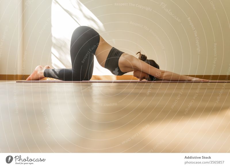 Flexible Frau, die Yoga in der erweiterten Welpenhaltung praktiziert Pose verlängerter Welpe üben Dehnung Übung Unterlage beweglich Windstille Sportkleidung