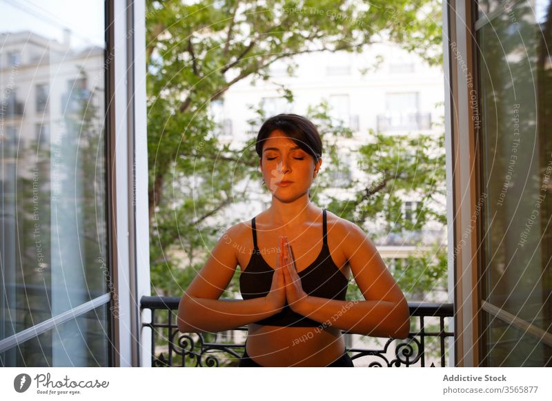 Ruhiges Stehen in Gebetspose auf dem Balkon im Sommer Frau Gebetshaltung Yoga Frieden Harmonie heimwärts sich[Akk] entspannen Augen geschlossen