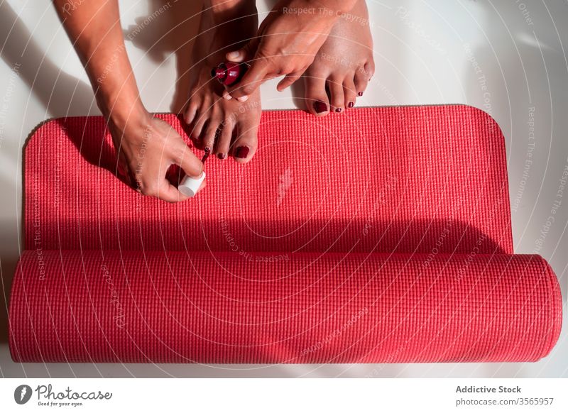 Frau macht zu Hause Pediküre auf Yogamatte Konzept Nagellack heimwärts Fuß bewerben Kosmetik verhindern Bund 19 Seuche Pandemie Selbstversorgung Accessoire