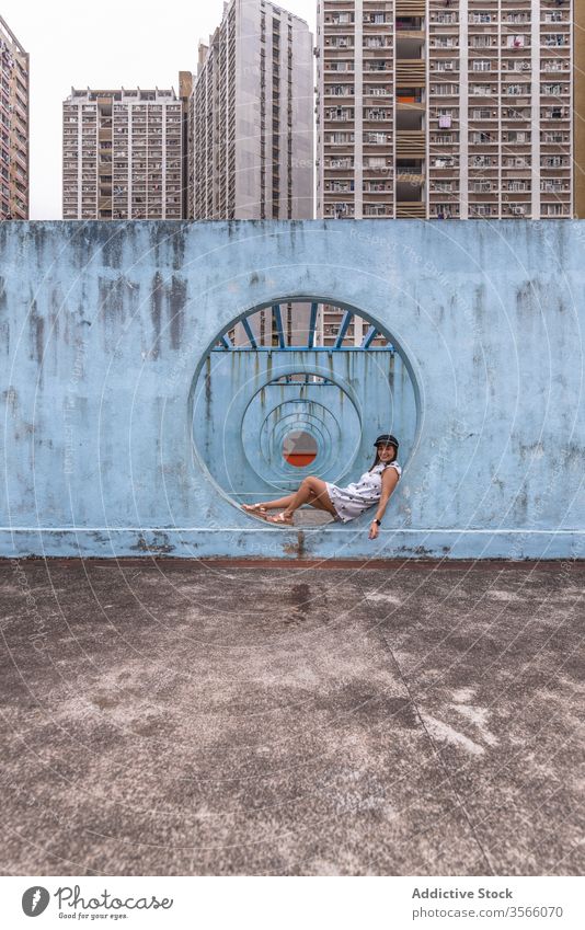 Frau sitzt an Mauern mit Tunnel in Hongkong Wand Stollen Durchgang Straße Installation Großstadt ungewöhnlich kreativ Sommer shek kip mei Hongkong Kong rund