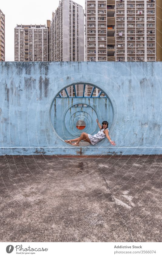 Frau sitzt an Mauern mit Tunnel in Hongkong Wand Stollen Durchgang Straße Installation Großstadt ungewöhnlich kreativ Sommer shek kip mei Hongkong Kong rund