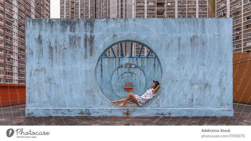 Frau ruht an Mauern mit Tunnel in Hongkong Wand Stollen Durchgang Straße Installation Großstadt ungewöhnlich kreativ Sommer shek kip mei Hongkong Kong rund