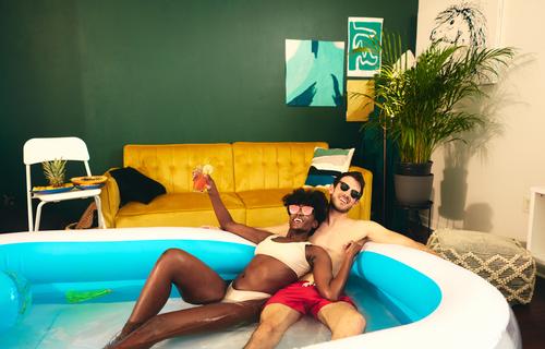 Inhalt multiethnisches Paar ruht sich im aufblasbaren Pool aus Party zu Hause bleiben Spaß haben Selbstisolierung verliebt soziale Distanzierung Wasser