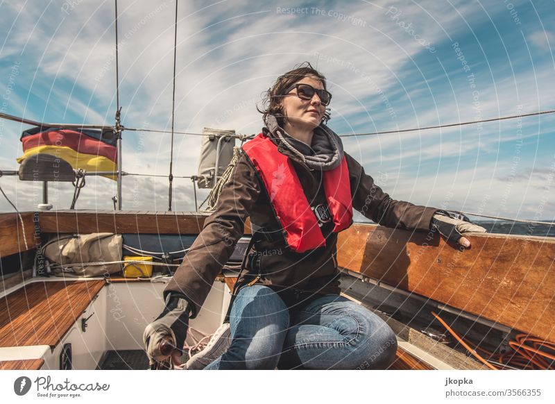 Junge Frau segelt auf der Ostsee Segeln Boot Yacht Jacht Segelboot Abenteuer Wasser Urlaub Schiff Nautisch Reisen Segelschiff Außenaufnahme Schiffsdeck Klassik