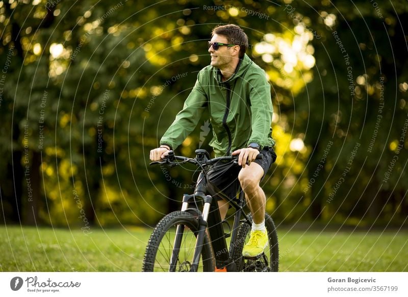 Junger Mann fährt E-Bike in der Natur Fahrrad Batterie Biker ebike Sport Berge u. Gebirge elektrisch Radfahren Sommer extrem Radfahrer grün im Freien reisen