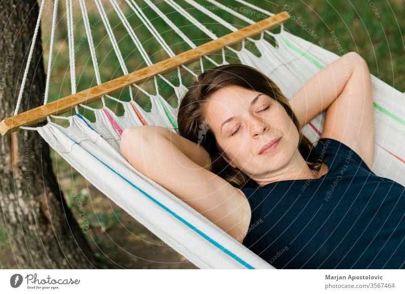 Junge Frau entspannt sich in der Hängematte in der Natur Erwachsener allein Hinterhof Windstille sorgenfrei lässig bequem Landschaft Tag träumen leicht genießen