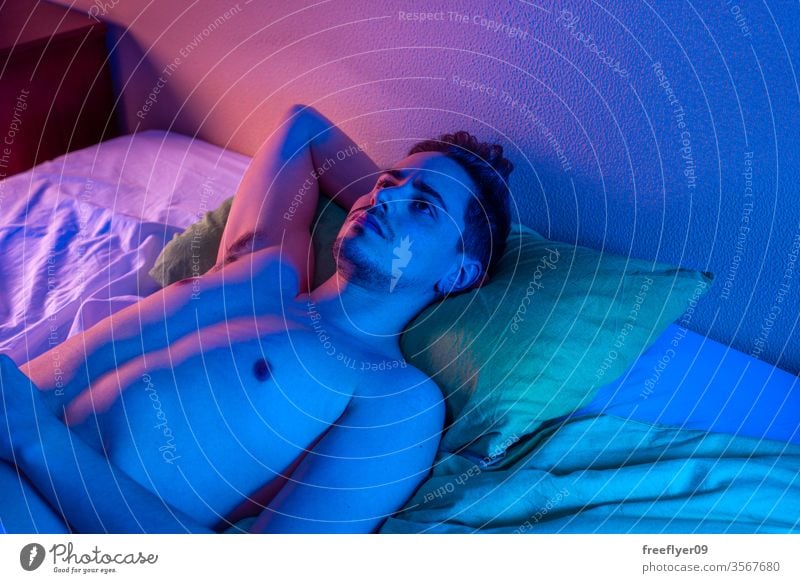 junger Mann mit Schlaflosigkeit, der versucht, nachts zu schlafen Porträt männlich Bett Nacht Quarantäne Depression Kopfkissen nackt von oben Coronavirus