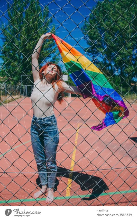 Junge rothaarige Frau feiert den Tag des Schwulenstolzes lgbti schwul Stolz Party Fahne Regenbogen Homosexualität lesbisch Farbe farbenfroh im Freien sozial