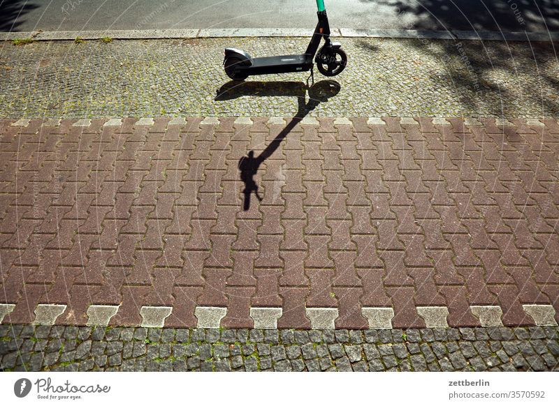 Roller auf dem Bürgersteig roller e-roller nahverkehr stehen warten abgestellt parken parkplatz weg bürgersteig fahrradweg pflaster pflastersteine licht