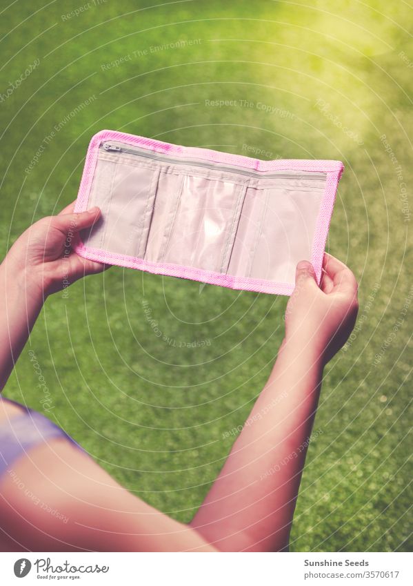Junges kaukasisches Mädchen mit leerer Brieftasche Lernen Kind jung Kunststoff purpur Währung Bargeld Einsparung Gewerbe Ausgaben Konzept kaufen Kauf Finanzen