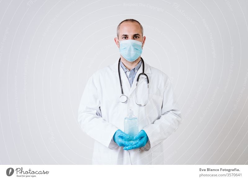 Arzt Mann mit alkoholhaltigem Desinfektionsgel. mit Schutzmaske und Handschuhen während der Coronavirus covid 2019 Pandemie. Gesundheitsversorgung und medizinisches Konzept