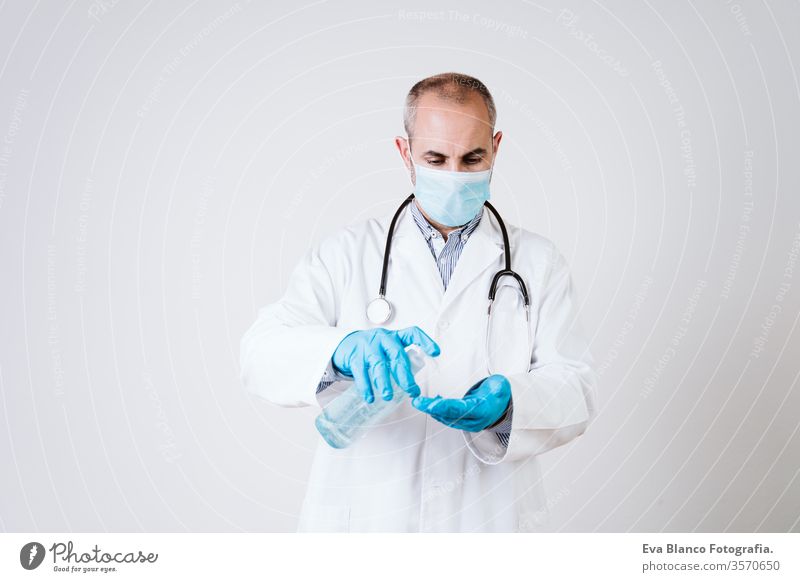 Arzt Mann mit Alkohol-Desinfektionsgel. mit Schutzmaske und Handschuhen während der Coronavirus covid 2019 Pandemie. Gesundheitsversorgung und medizinisches Konzept
