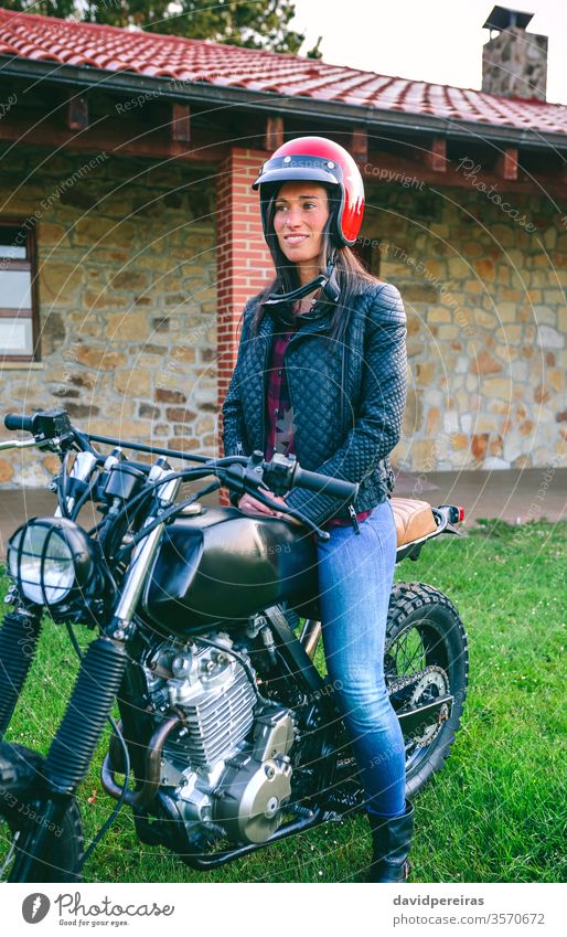 Frau mit Helm auf einem Custom-Motorrad Mädchen Schutzhelm Biker benutzerdefiniert altehrwürdig Fahrrad retro Warten Reiter Fahrzeug schön Model Verkehr
