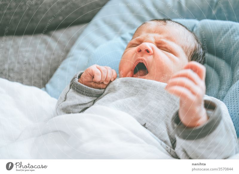 Kleines neugeborenes Mädchen, das sich hinlegt und versucht, sich zu entspannen Baby Neugeborene Geburt erster Tag Junge Mama Familie Glück Fröhlichkeit Pflege