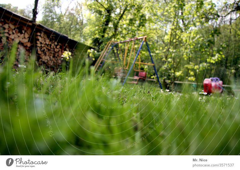 im Garten Wiese Rasen Gras grün Sommer Natur Pflanze Schrebergarten Schaukel schaukeln Spielen Froschperspektive Erholung Idylle Holzstapel Wippe Spielplatz
