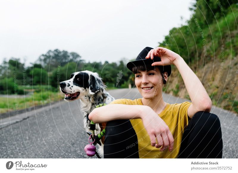 Positive junge Frau sitzt mit ihrem Hund am Boden auf der Straße Natur Zusammensein Hipster Haustier Liebe Glück Begleiter Freund positiv englischer Setter