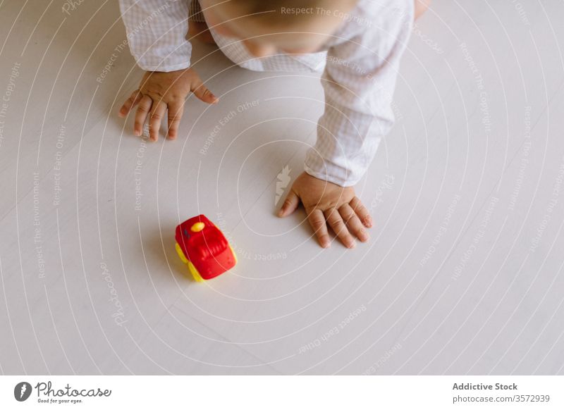 Süßes kleines Kind spielt mit Spielzeugauto krabbeln wenig spielen Kleinkind Wochenende unterhalten Spaß haben PKW Kindheit niedlich bezaubernd hölzern Stock