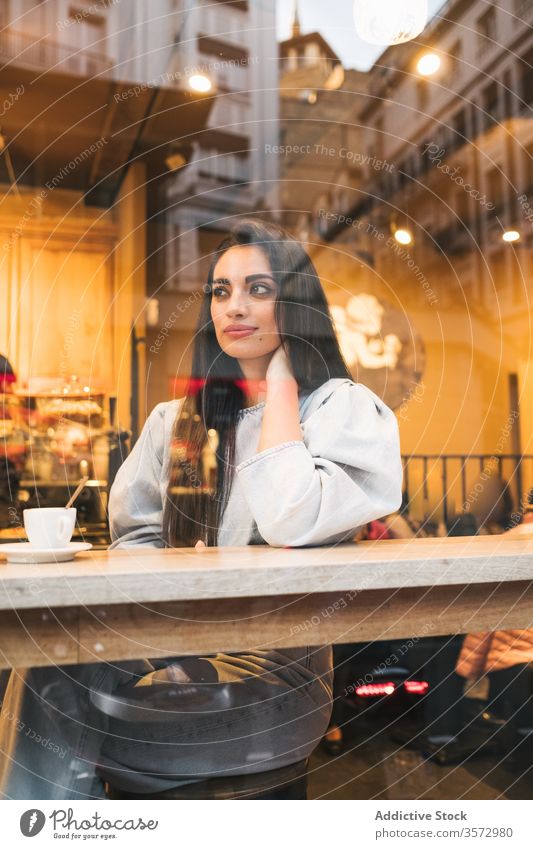 Fröhliche junge Frau sitzt im Cafe Café heiter trendy Stil genießen Kaffee Fenster Abfertigungsschalter trinken gemütlich Kantine sich[Akk] entspannen Glück