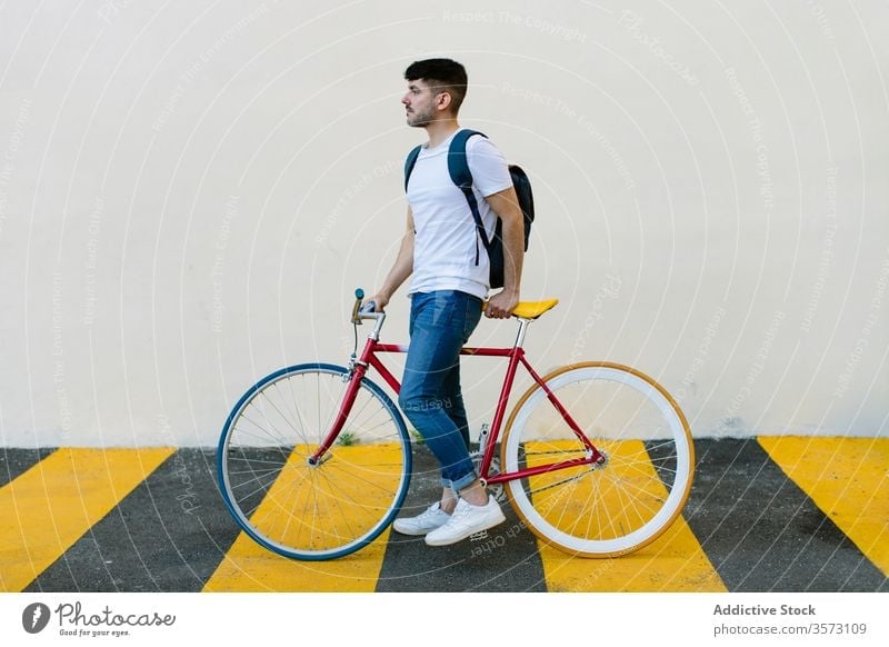 Kaukasischer Mann auf einem Fixie Fahrrad Zyklus urban Rad feststehend Sport Transport Ausrüstung Lifestyle Wand Straße Hipster Mitfahrgelegenheit Pedal